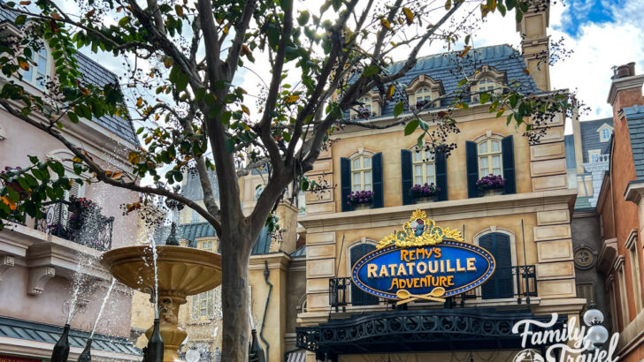 The outside of Remy's Ratatouille Adventure with a tree and fountain in the foreground