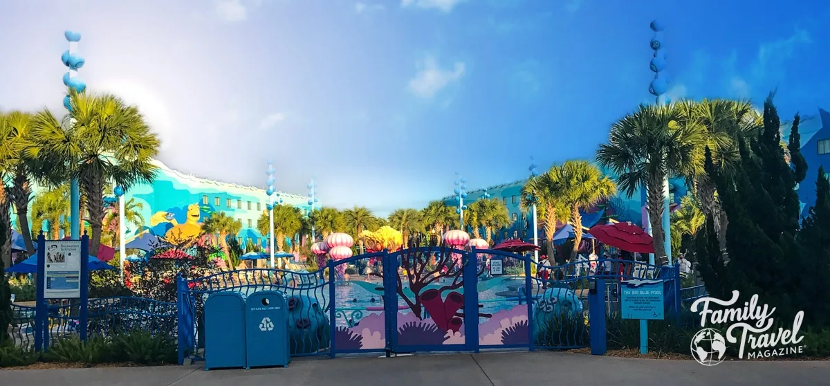 The Deep Blue Pool from the other side of the fence with colorful Nemo decor and palm trees - (the best Disney World hotel for toddlers)