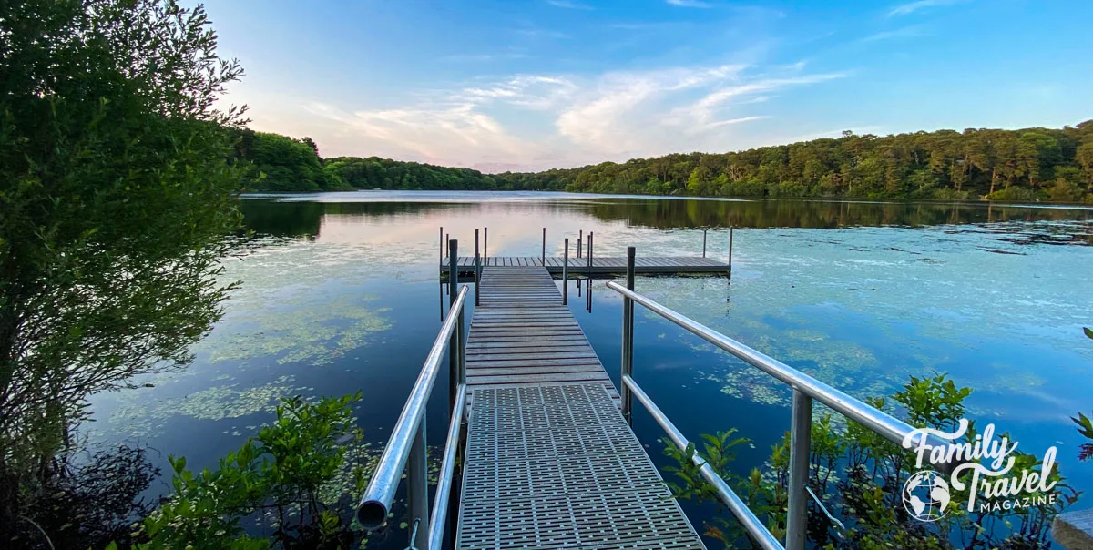 Large pond with pier and trees surrounding it at Ocean Edge Resort.