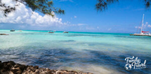 small boats and sailboat in the turquoise water