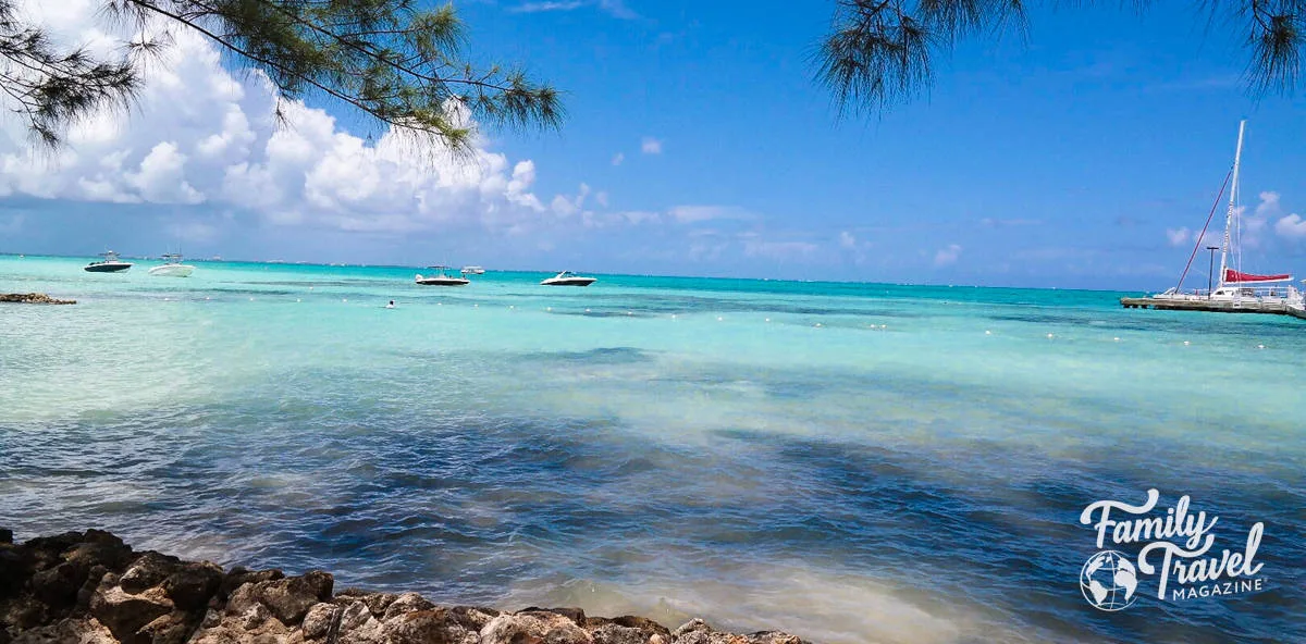 small boats and sailboat in the turquoise water