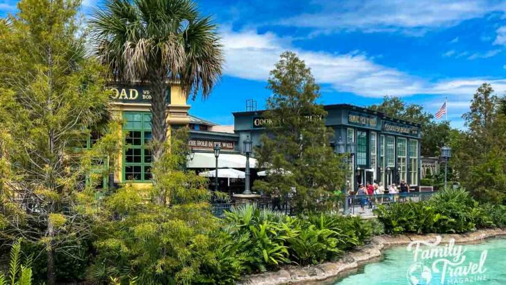 three restaurants along a body of water with palm trees