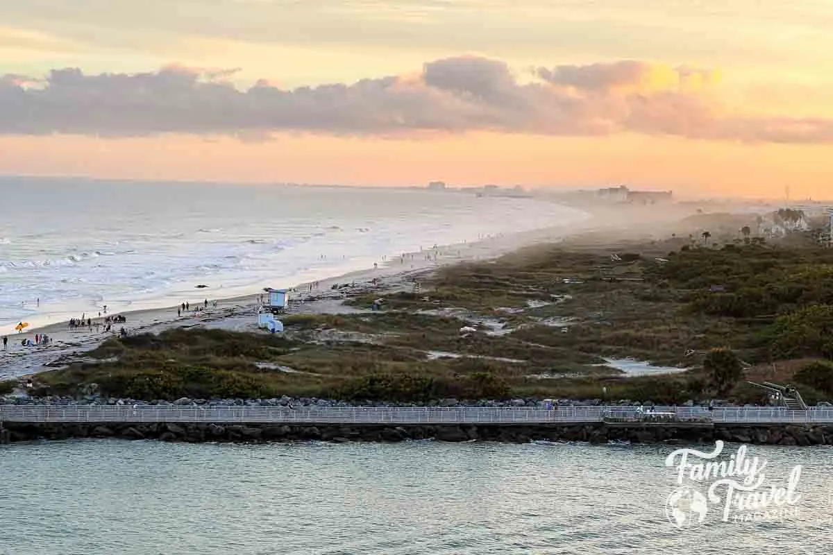 Pier and beach from a distance with sun setting