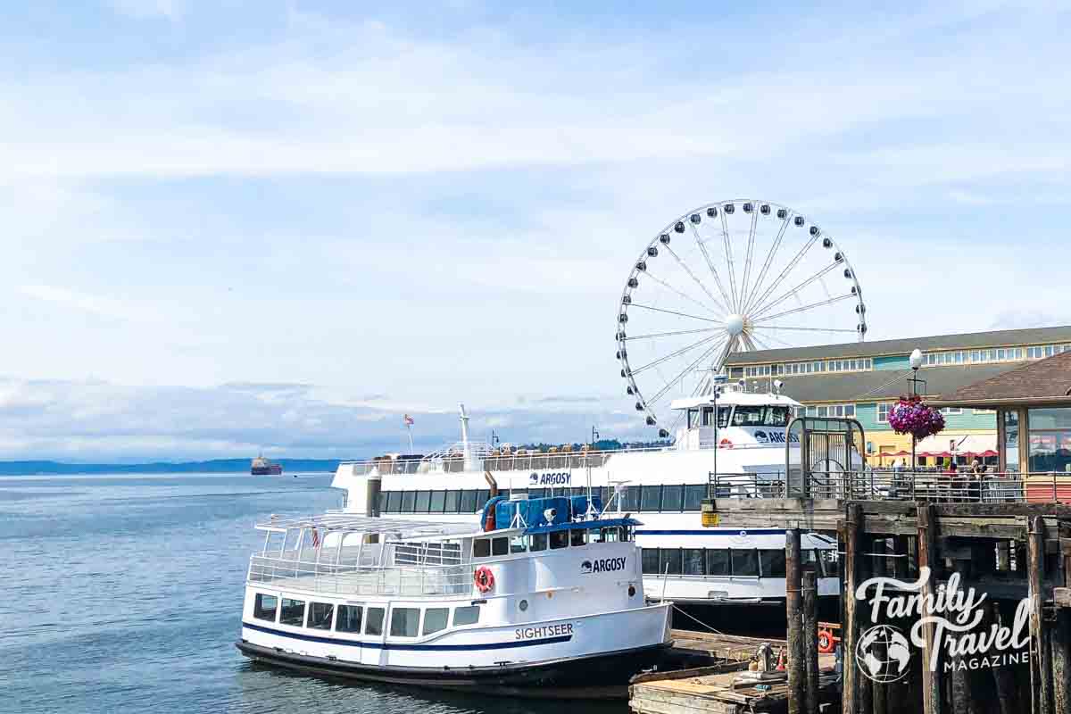 Sightseeing boats on the pier with wheel in the background