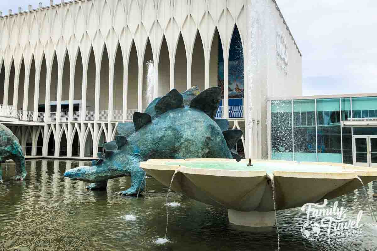 Dinosaur statue on pool of water with fountain