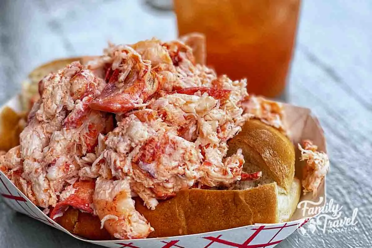 Huge lobster roll with rum punch in the background