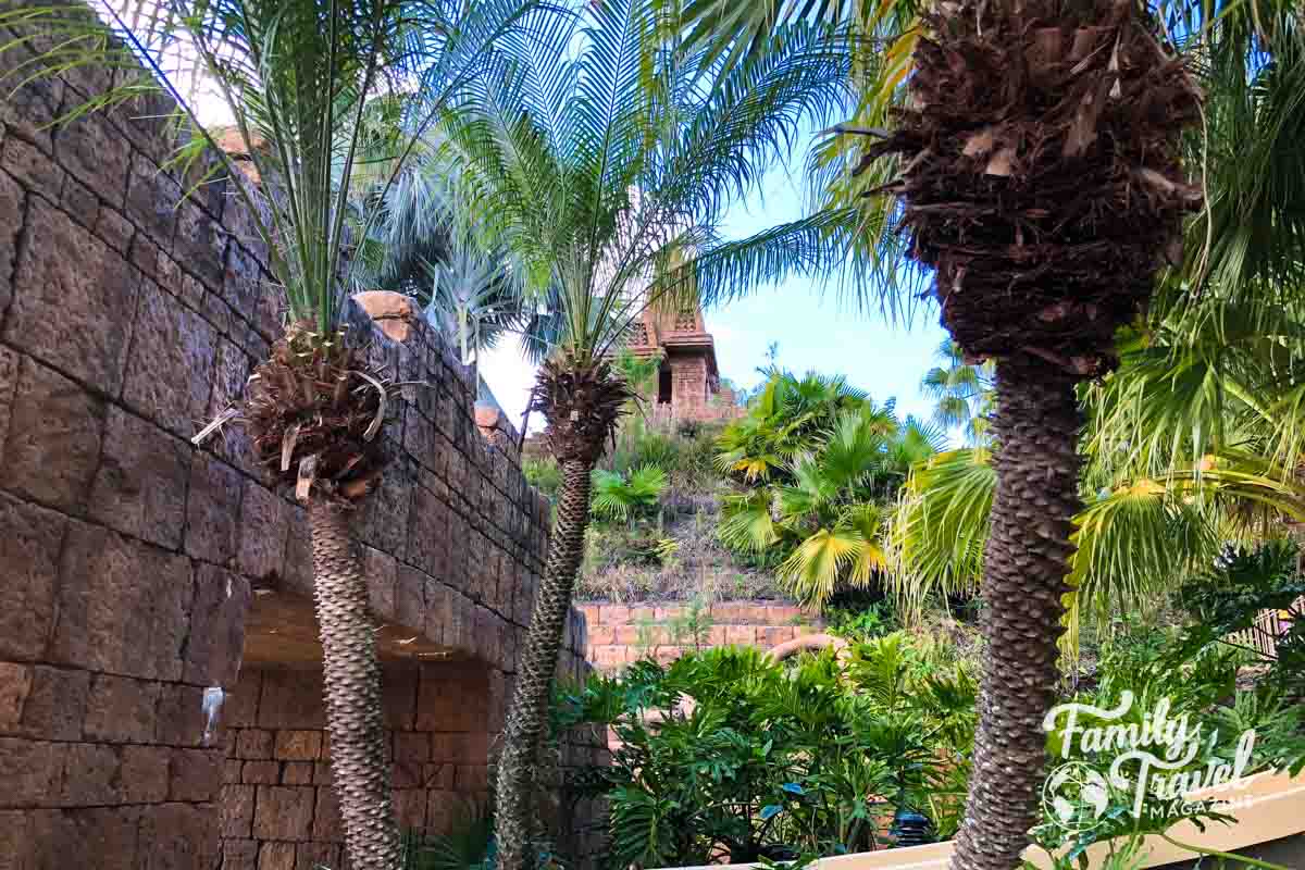 Dig site pool from a distance with trees and walls in the foreground