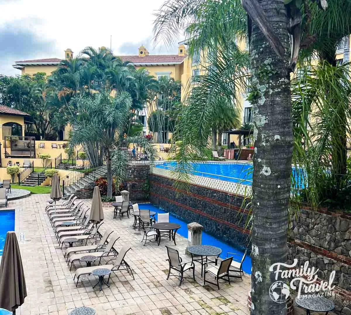 Pool area with palm trees and greenery