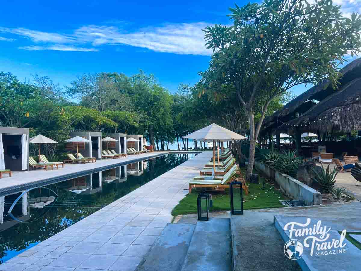 Pool area with seats, umbrellas, and cabanas