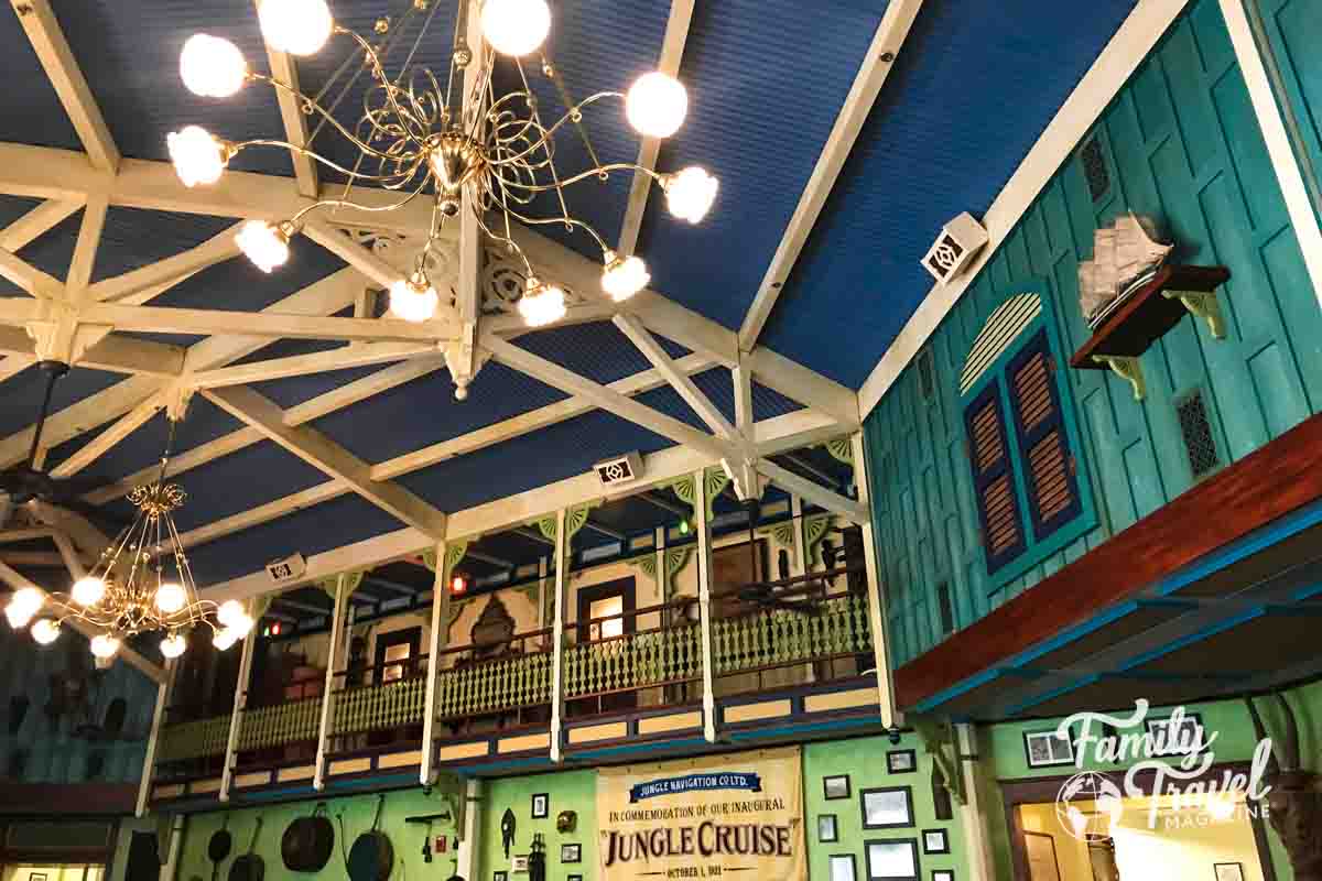 Colorful upper walls and ceiling with shutters, fans, chandelier. 