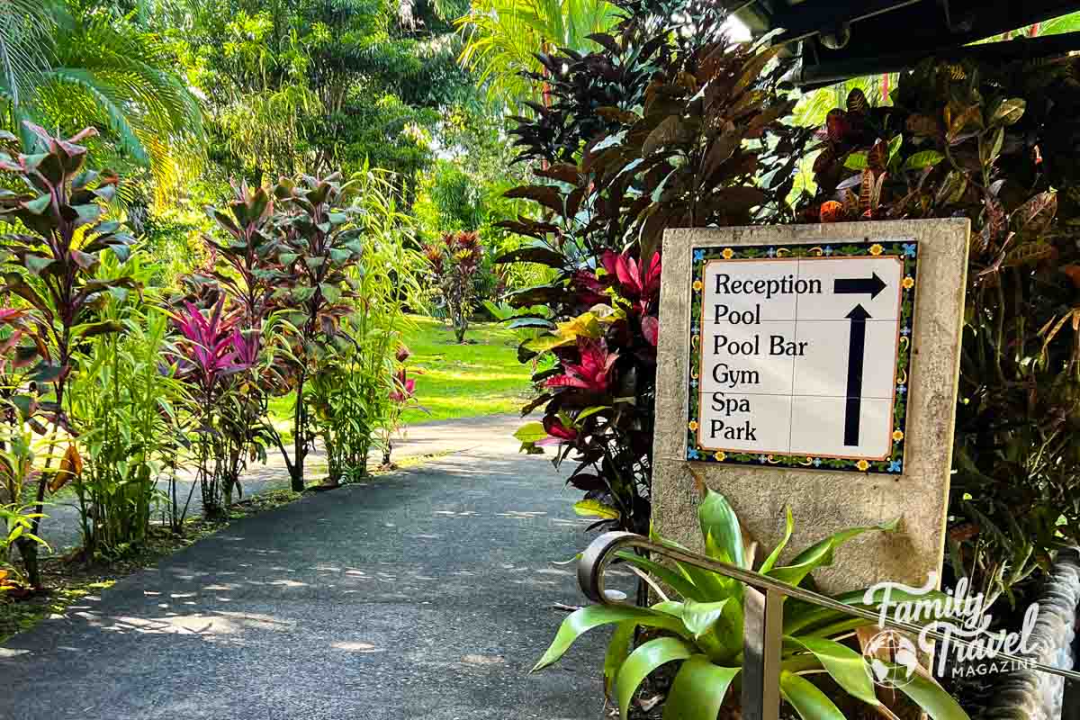 sign showing hotel amenities in the rainforest with colorful plants