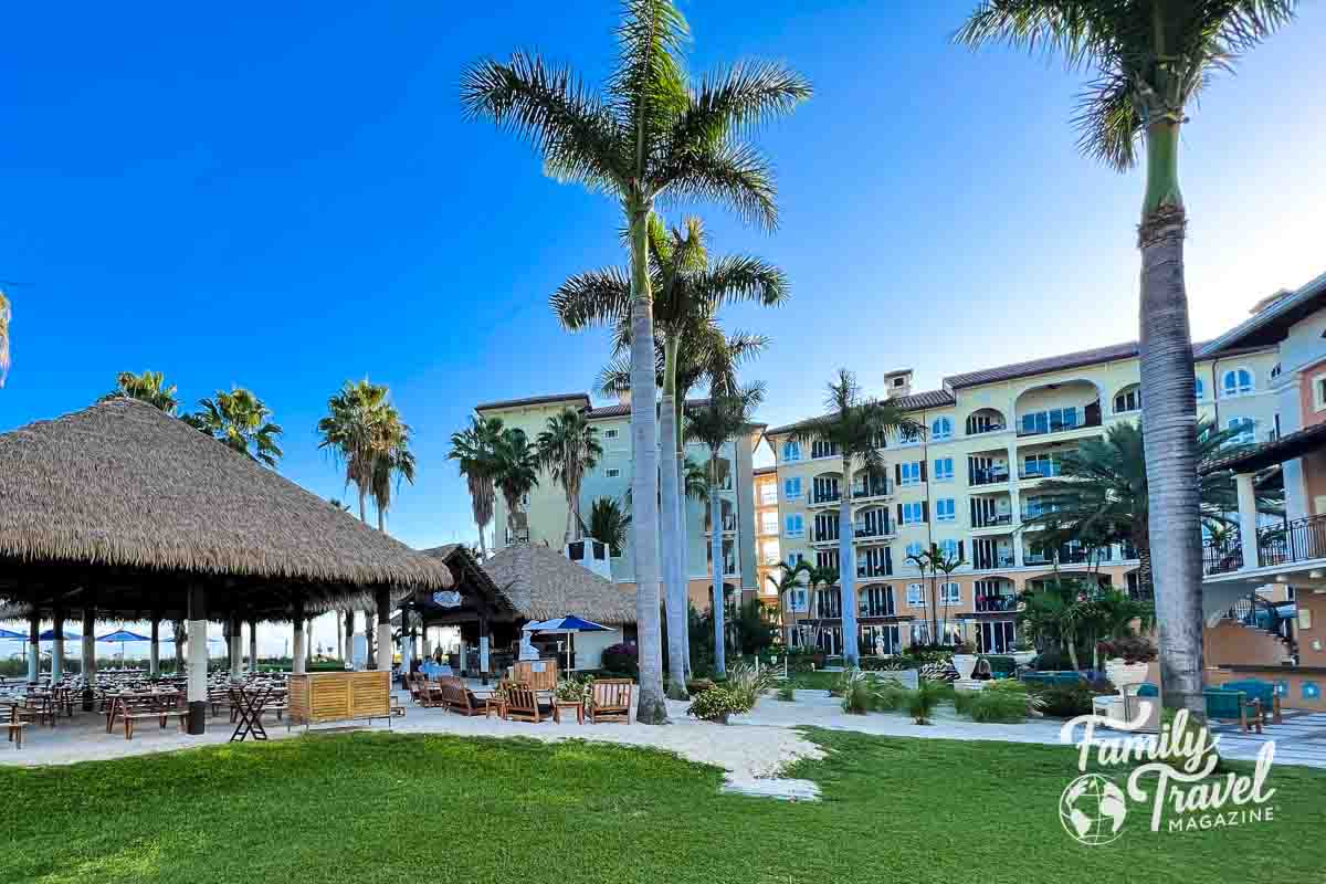 Building with hut and palm trees in foreground