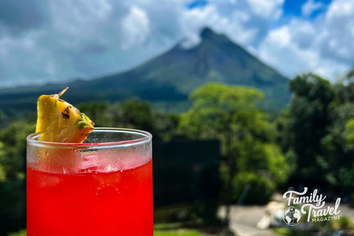 Red juice with pineapple slice in front of volcano