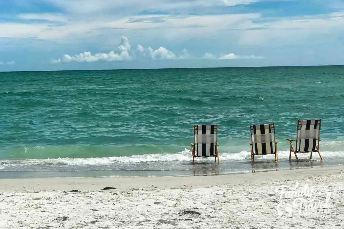 Blue and white beach chairs at the edge of the water