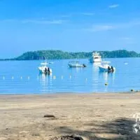 Boats in water with beach in foreground