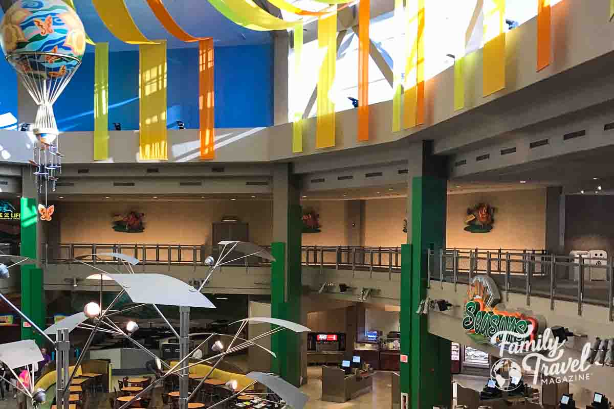 Interior of Sunshine Seasons market with colorful banners, tables, and chairs