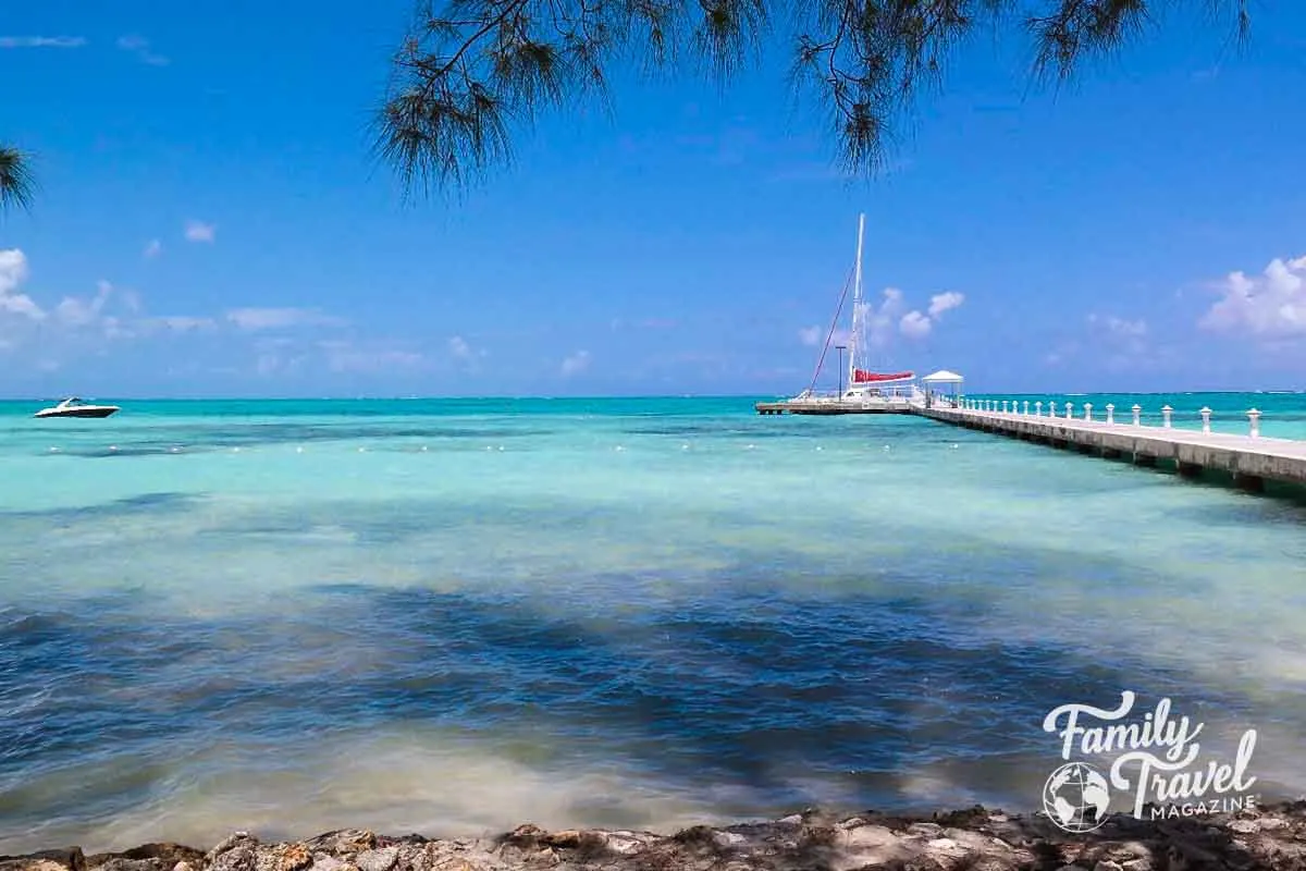 sailboat docked next to pier with clear turquoise water