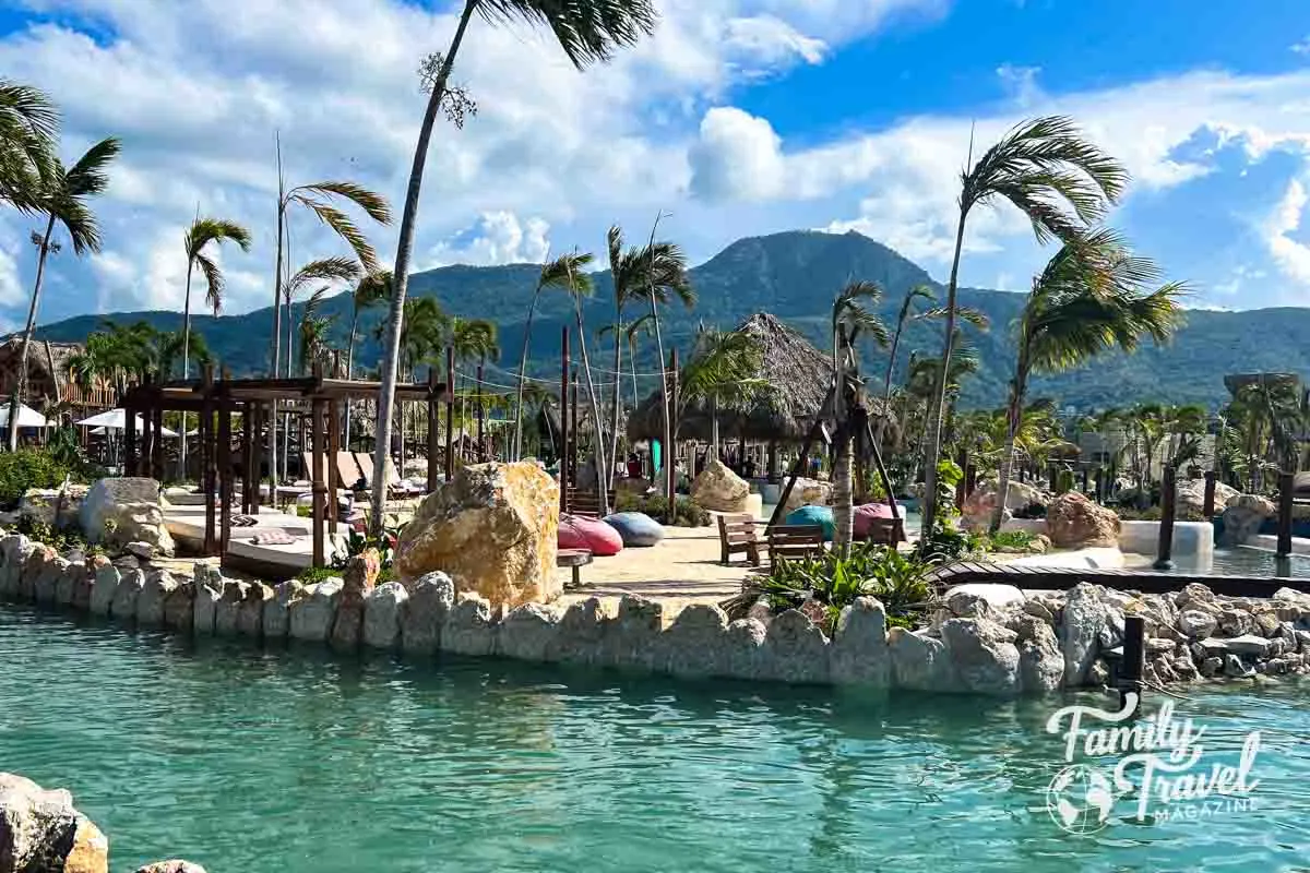 Lazy river with palm trees, beach loungers, and chairs