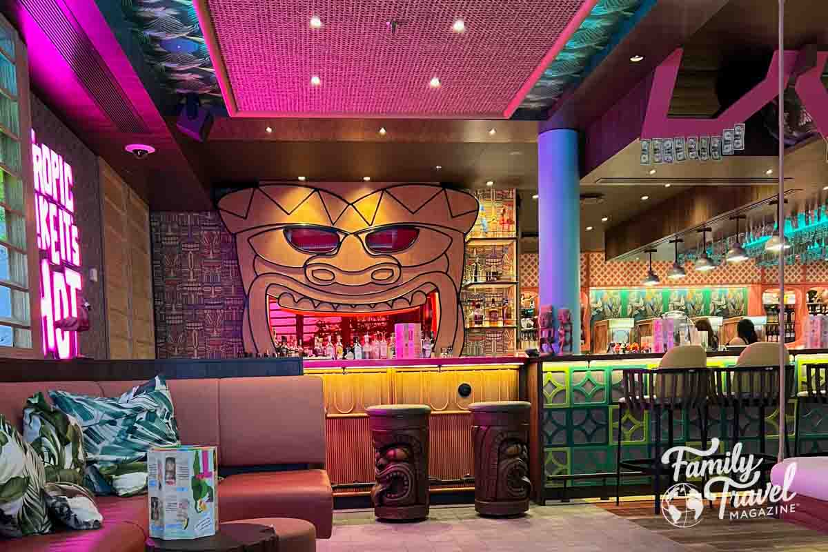 Tiki design on wall behind a colorful bar.