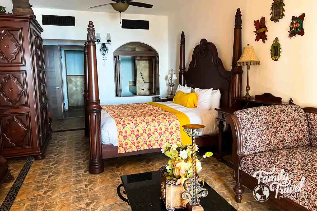 Hotel bedroom with king bed, sofa bed, dark wood furnishings