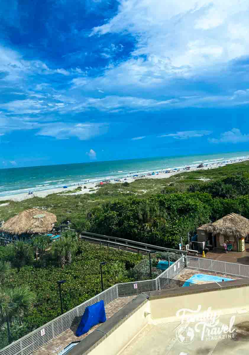 View from room including beach, beach foliage, tiki huts, and roof