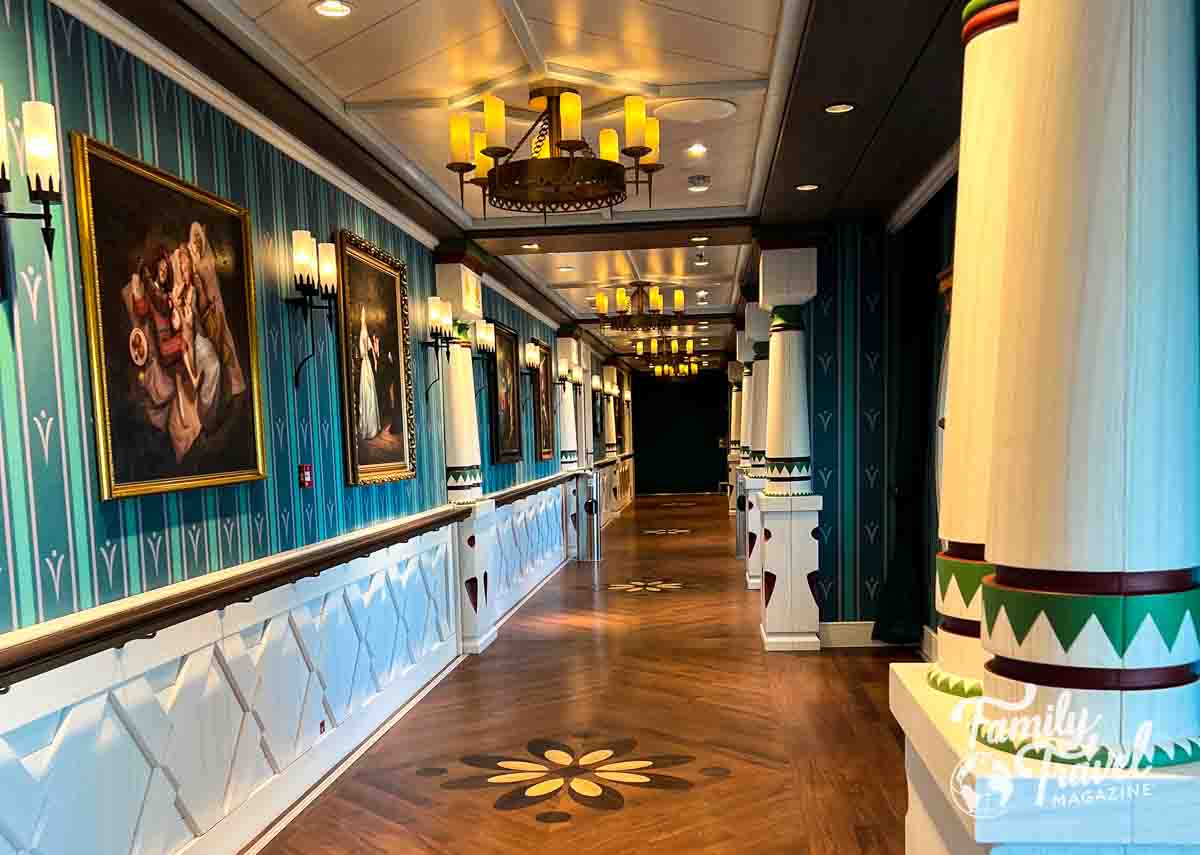 Hallway leading to Arendelle restaurant with pictures on the wall and columns