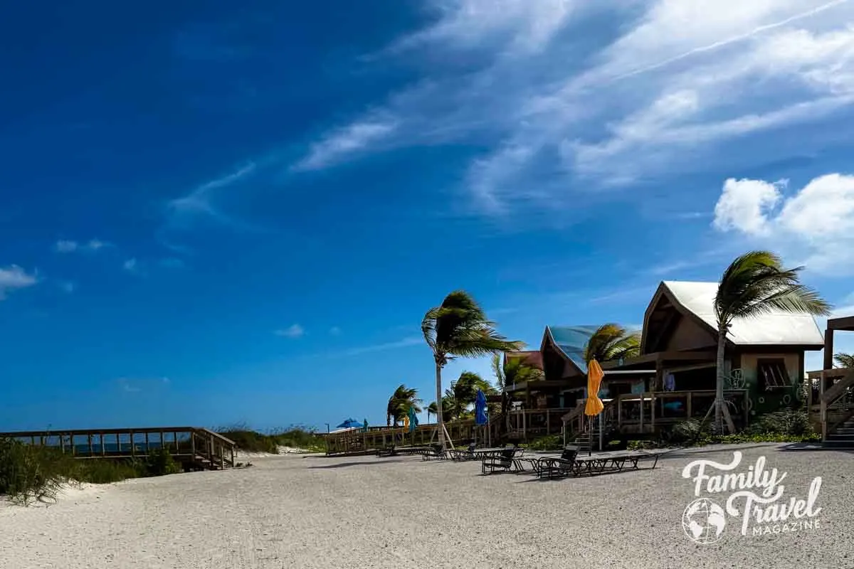 Cabanas with trees and beach chairs on the sand