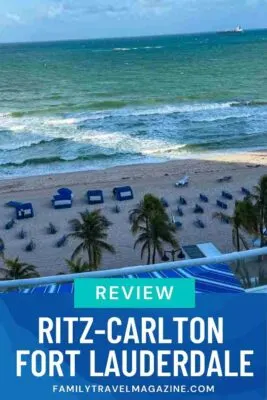 Beach view from above with umbrellas, chairs, and palm trees