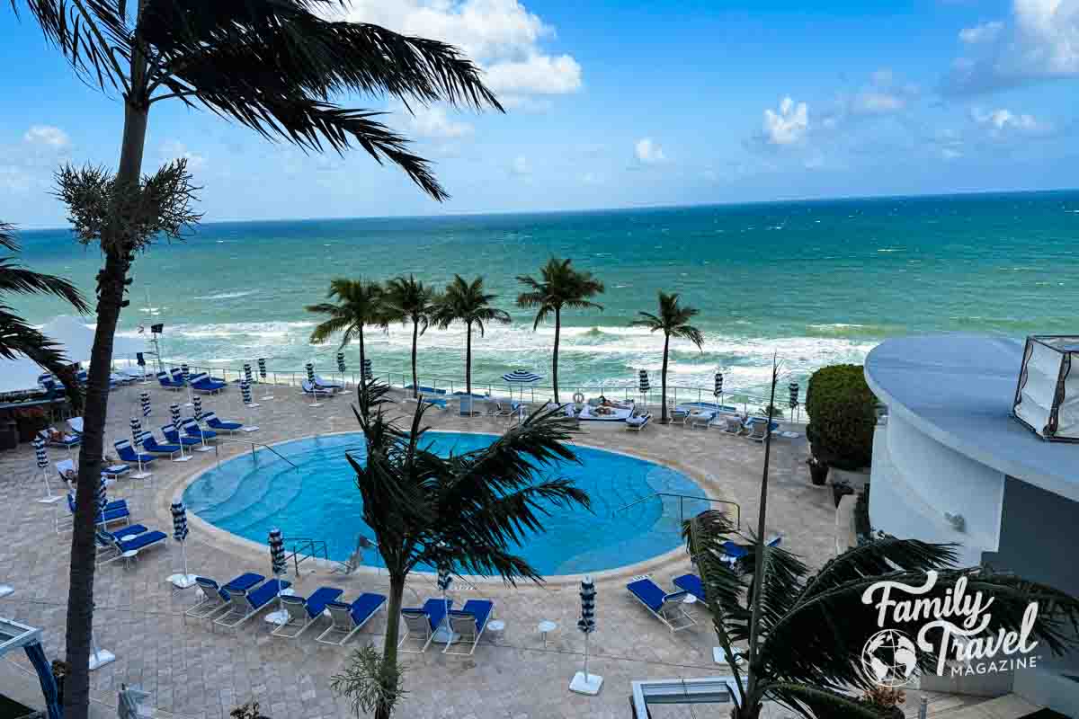 Pool with beach chairs above a beach 