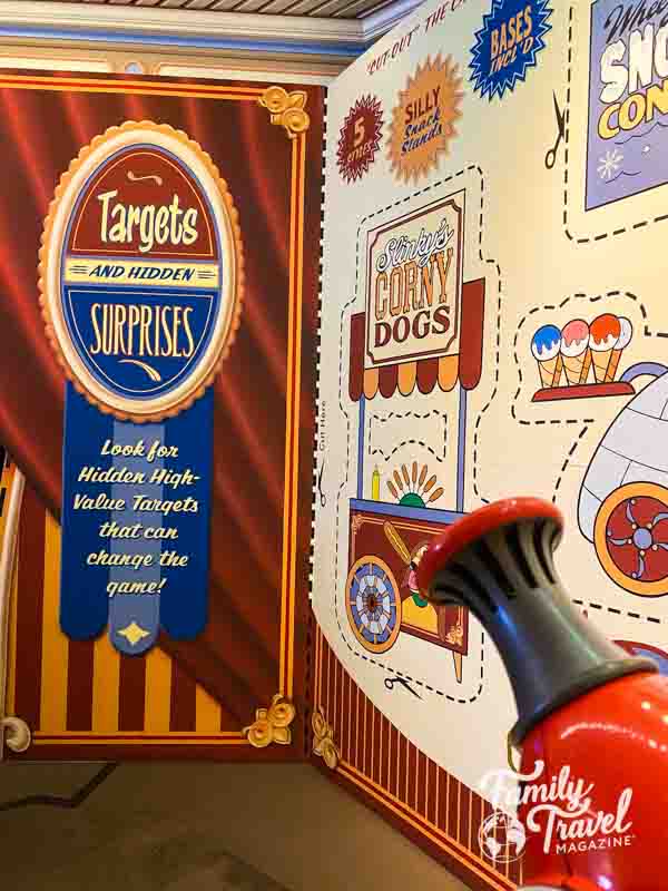 Toy Story Midway Mania walls with  midway motifs and ride vehicle in the foreground